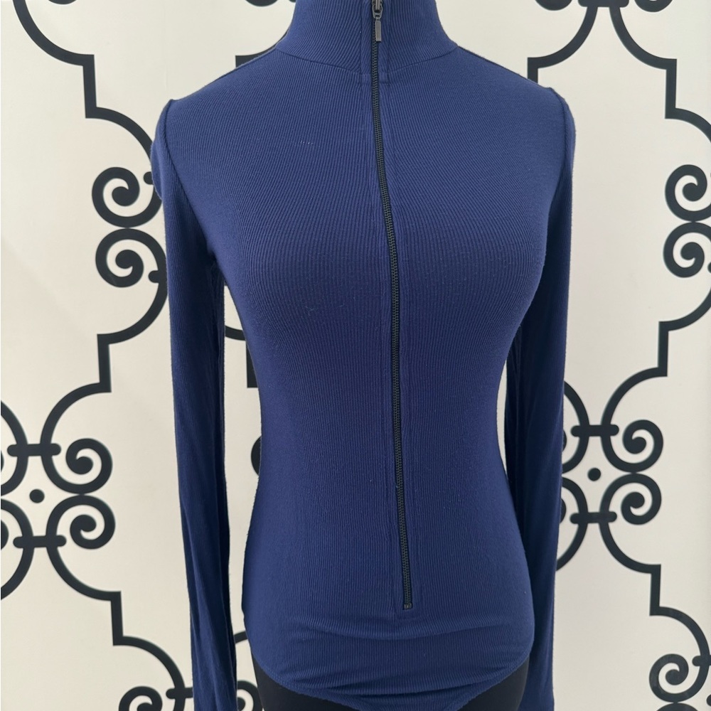 Fitted long sleeve Guess body suit with front zipper.